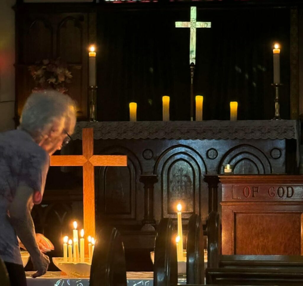 woman lighting candles during Taize worship