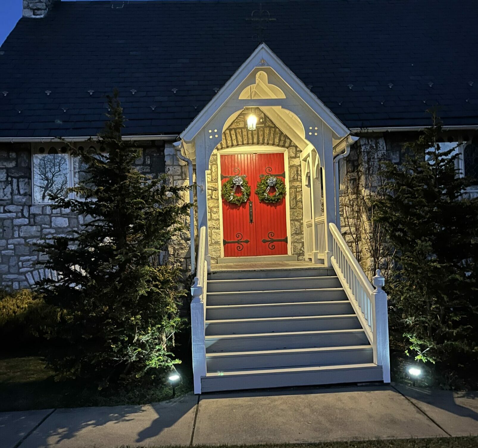 red church doors tdecorated with christmas wreaths